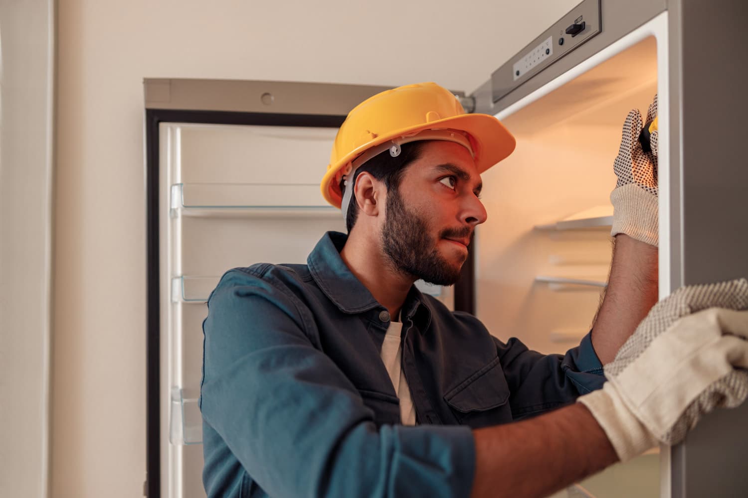 Technicien réparant un frigo